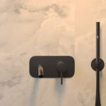 Close up foto van een badkraan met Fibo wandpanelen op de muur van de collectie Arctic Onyx zonder voeglijn